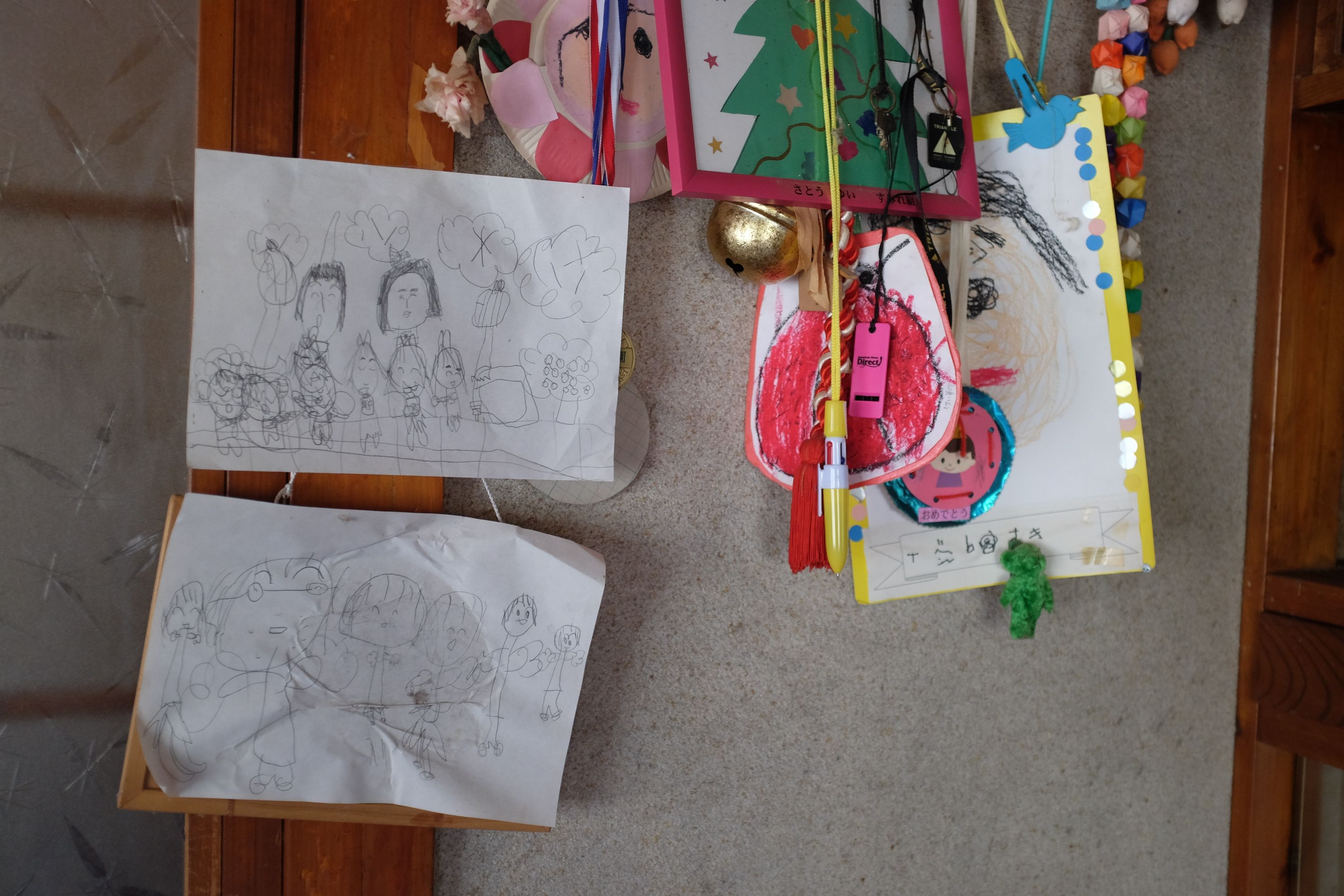 Children’s drawing and various school stuff hanging from a wall.