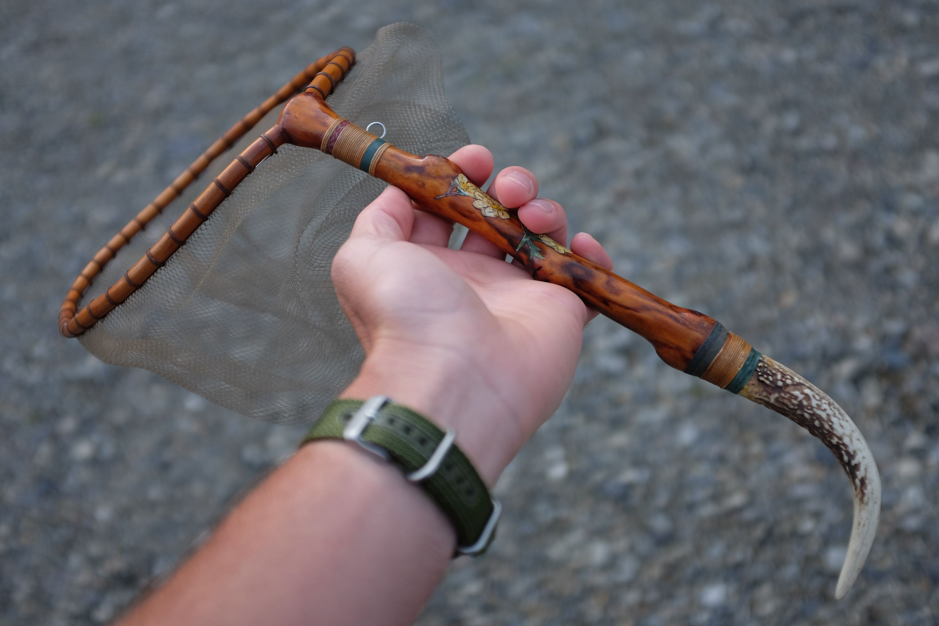 The author holds a painted landing net in his left hand.