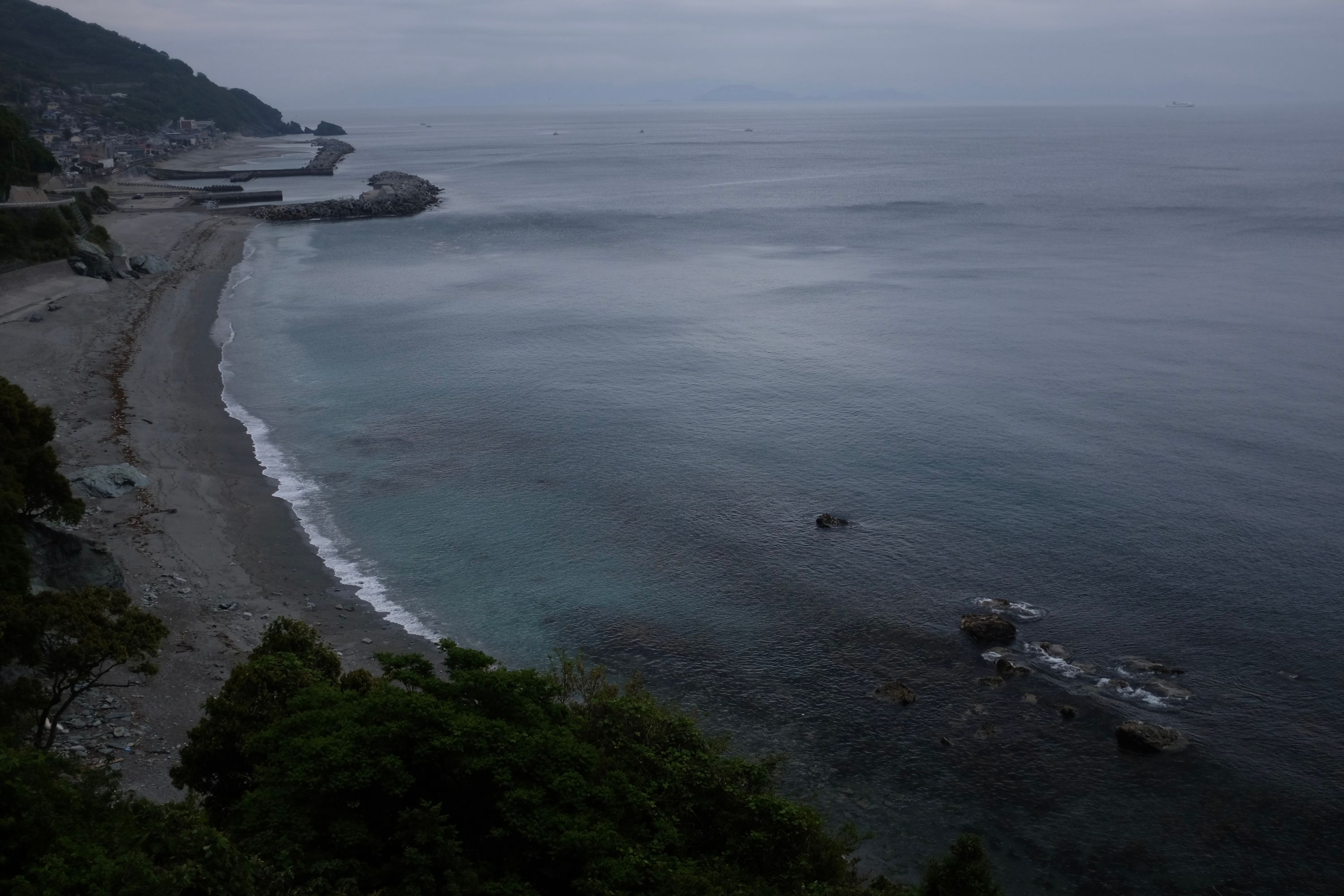 Looking out under an overcast sky over the sea and the village of Ōku.
