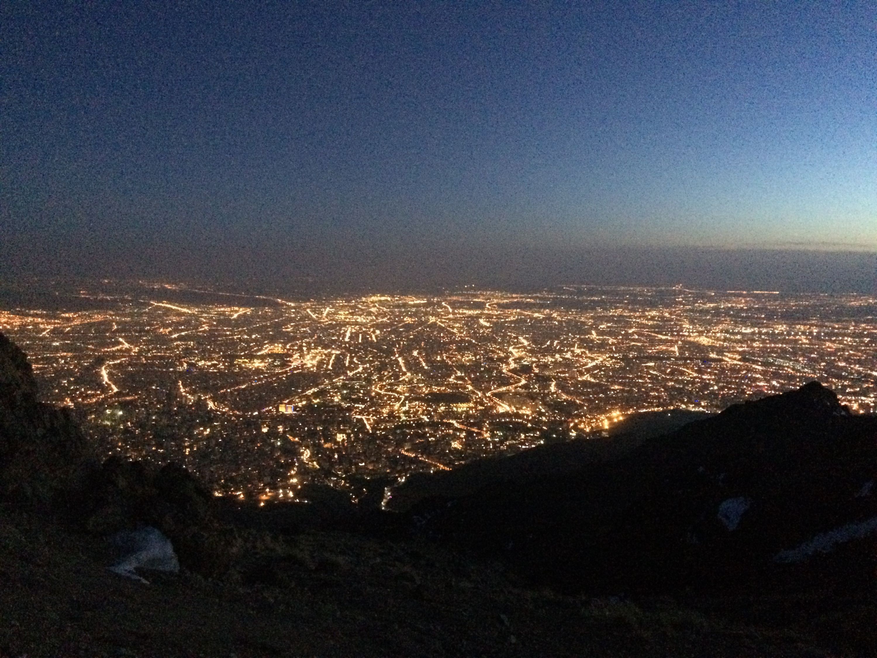 The lights of an enormous city stretch to the horizon.