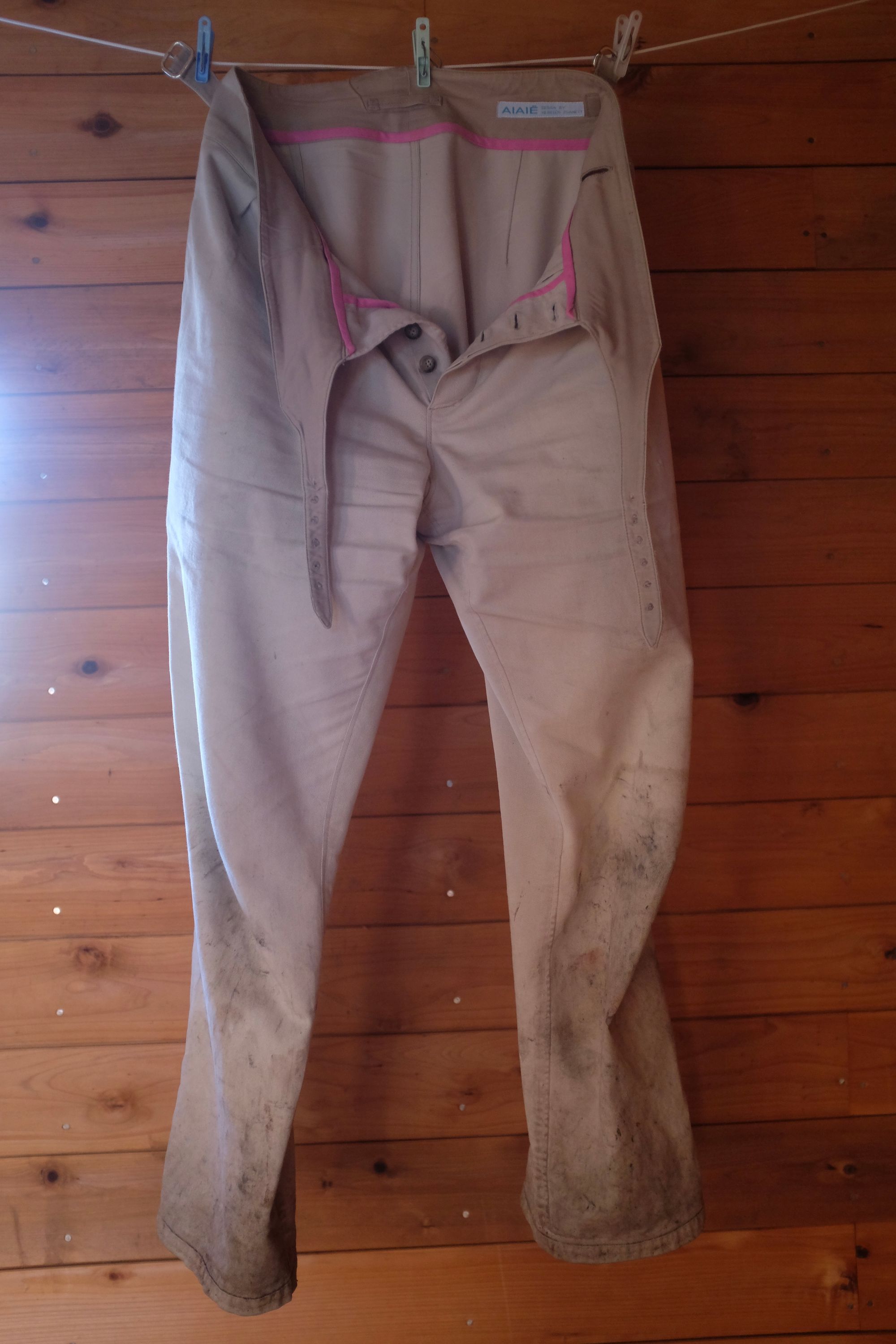 The author’s muddy trousers hanging from a clothesline in a mountain hut.
