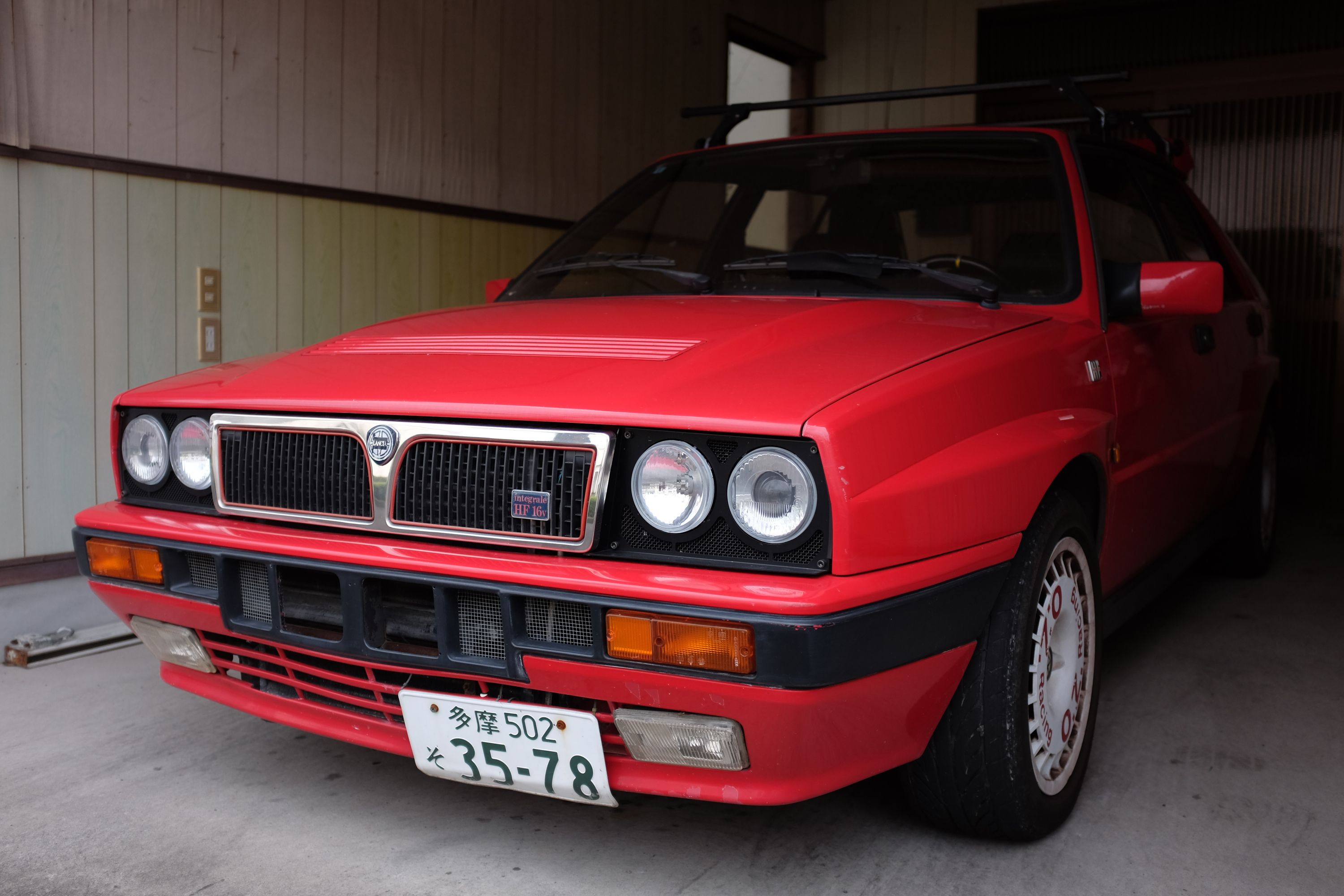 A red Lancia Delta HF Integrale in a garage.