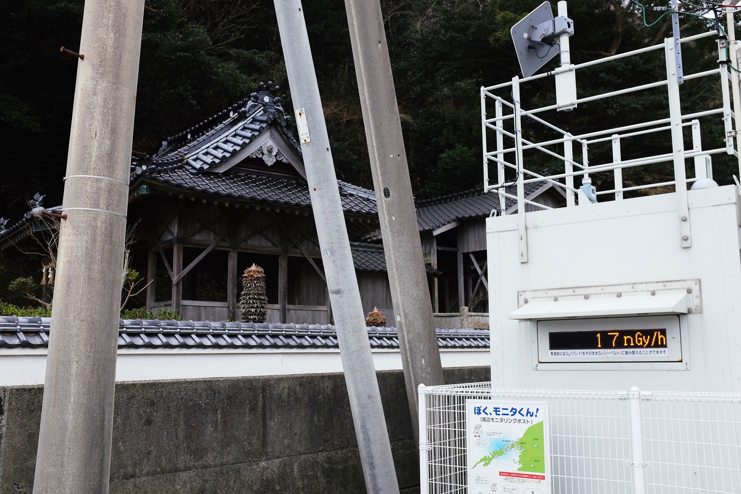 A radiation monitor showing 17 nanograys per hour next to a Japanese shrine.
