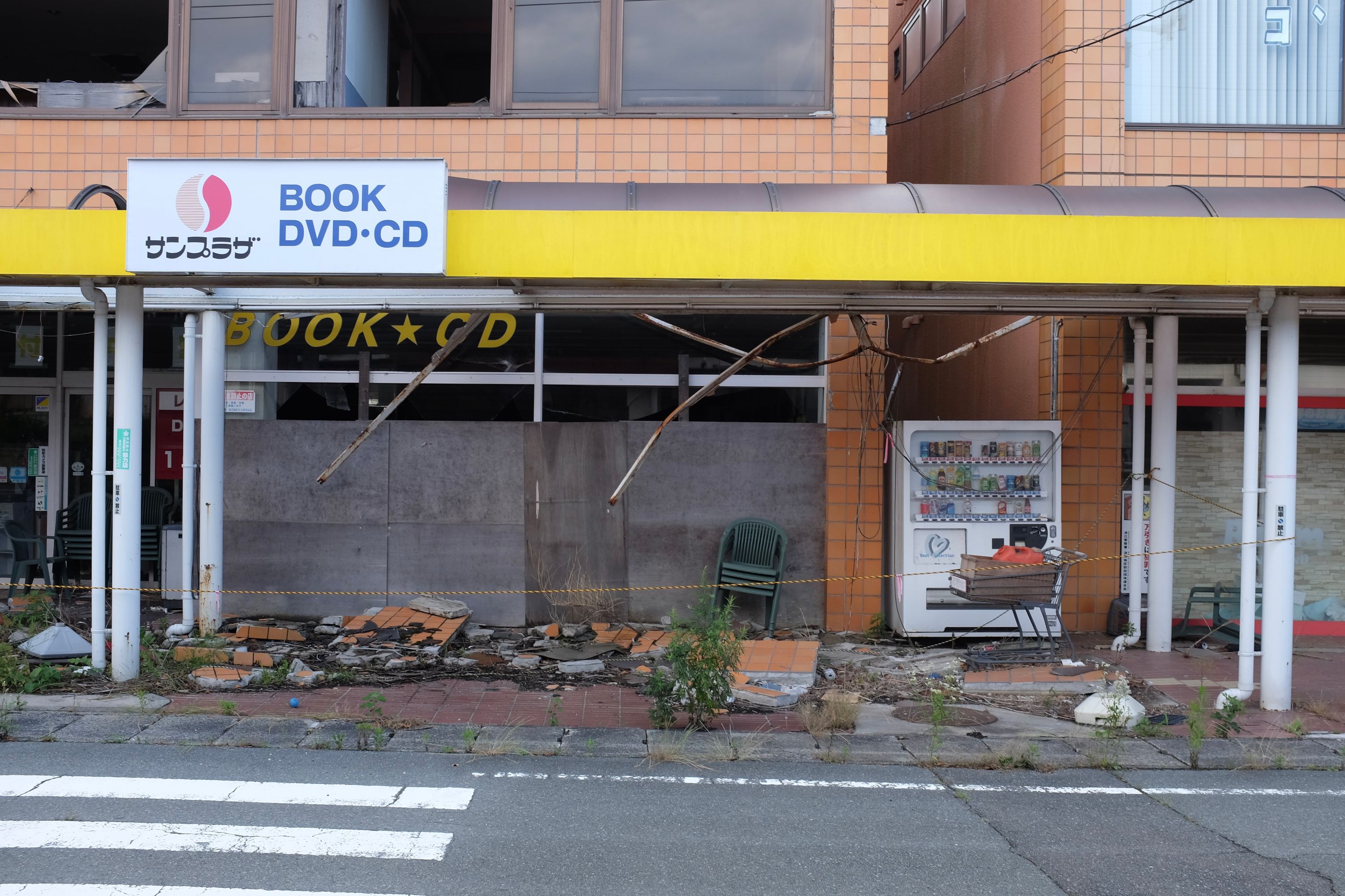 Debris and abandoned items in front of a damaged shop.