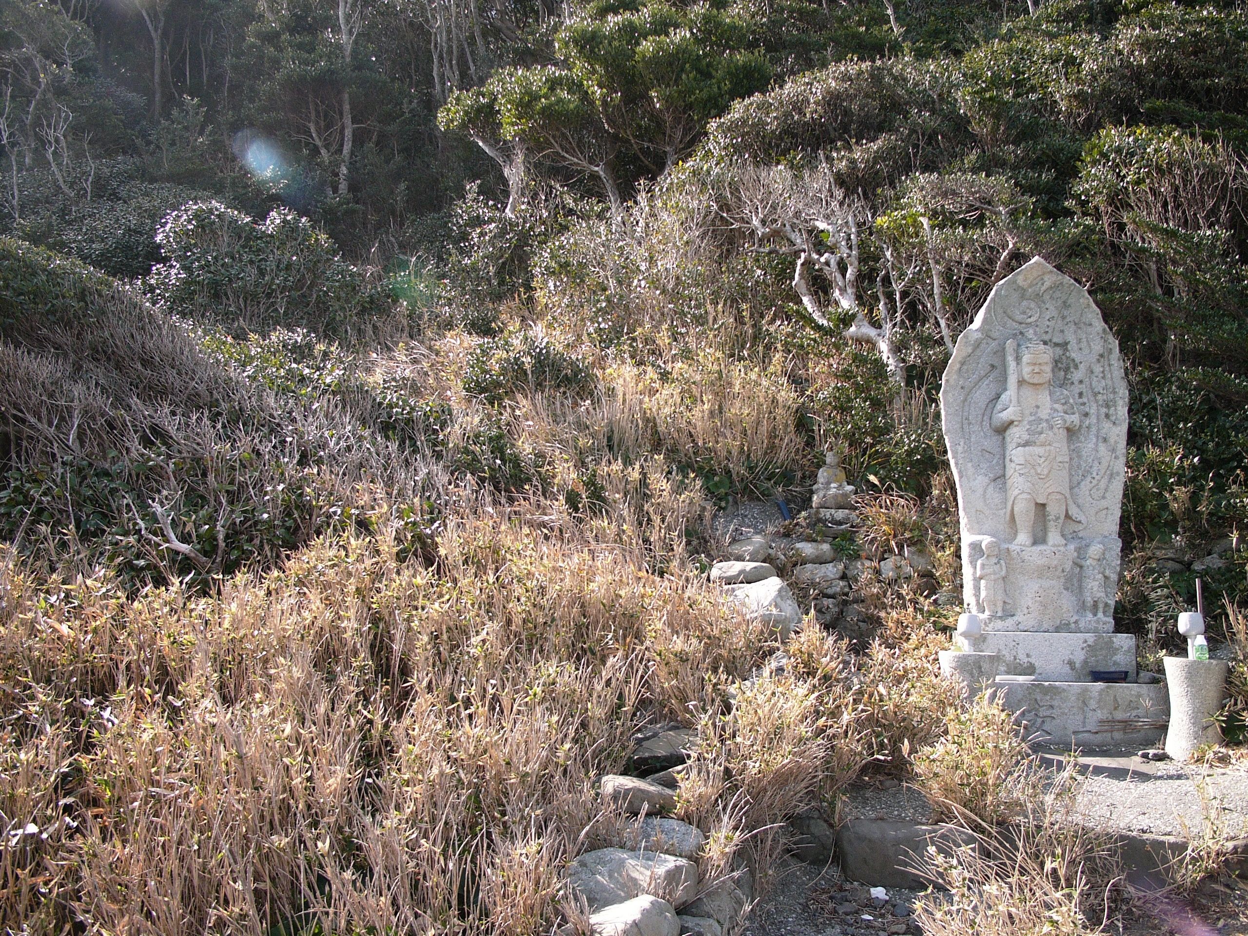 A small statue of a Buddhist guardian in the slanting afternoon light.