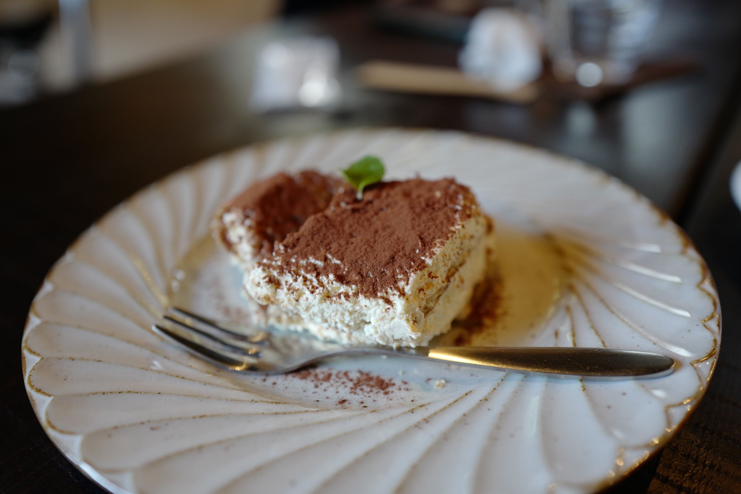 A piece of tiramisù on a plate. Both the plate and the cake look very fancy for a village cafe.