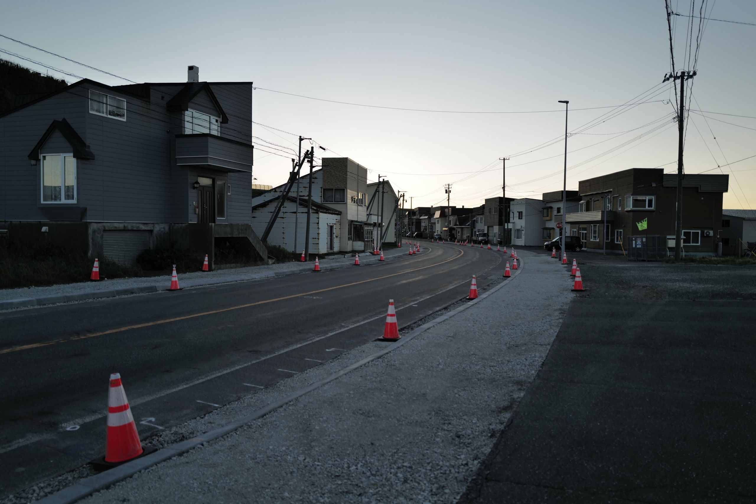 A sidewalk under construction in a village of new-looking houses