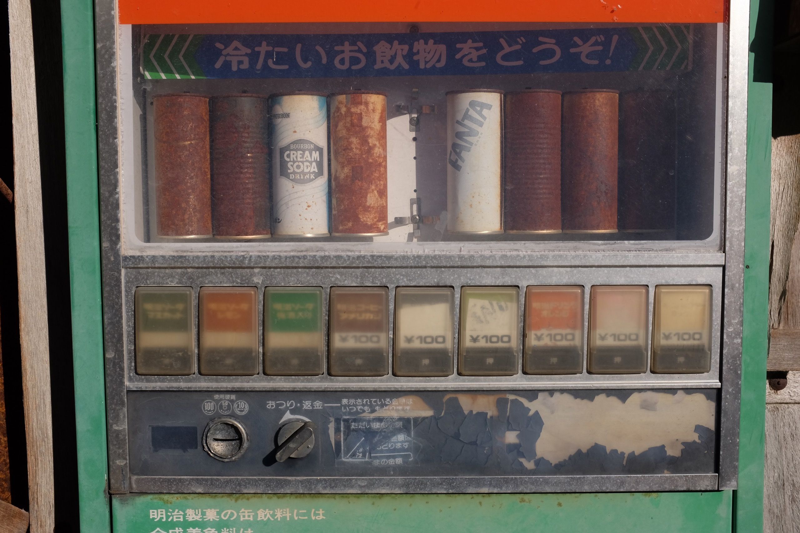 Cans of soda in an abandoned vending machine.
