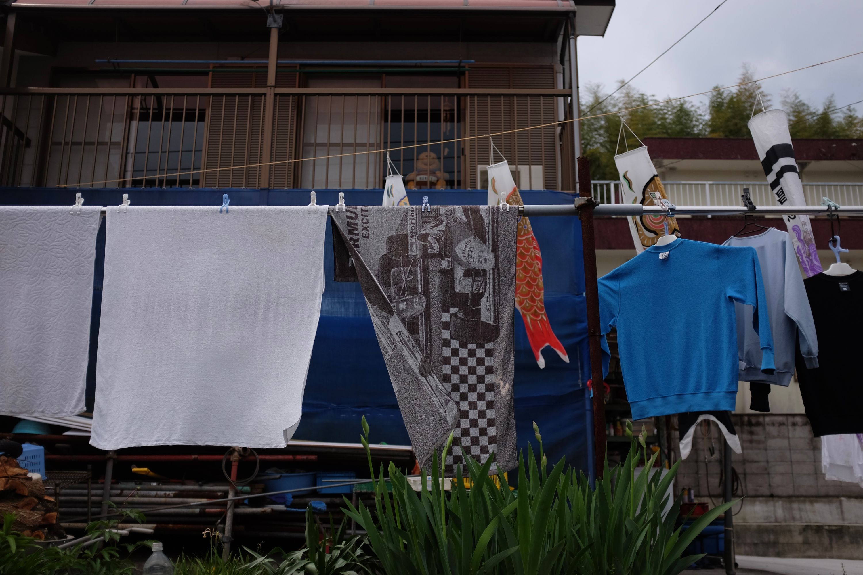 Towels and shirts drying on a rack, one of the towels shows Ayrton Senna’s McLaren from a 1980s Grand Prix race.