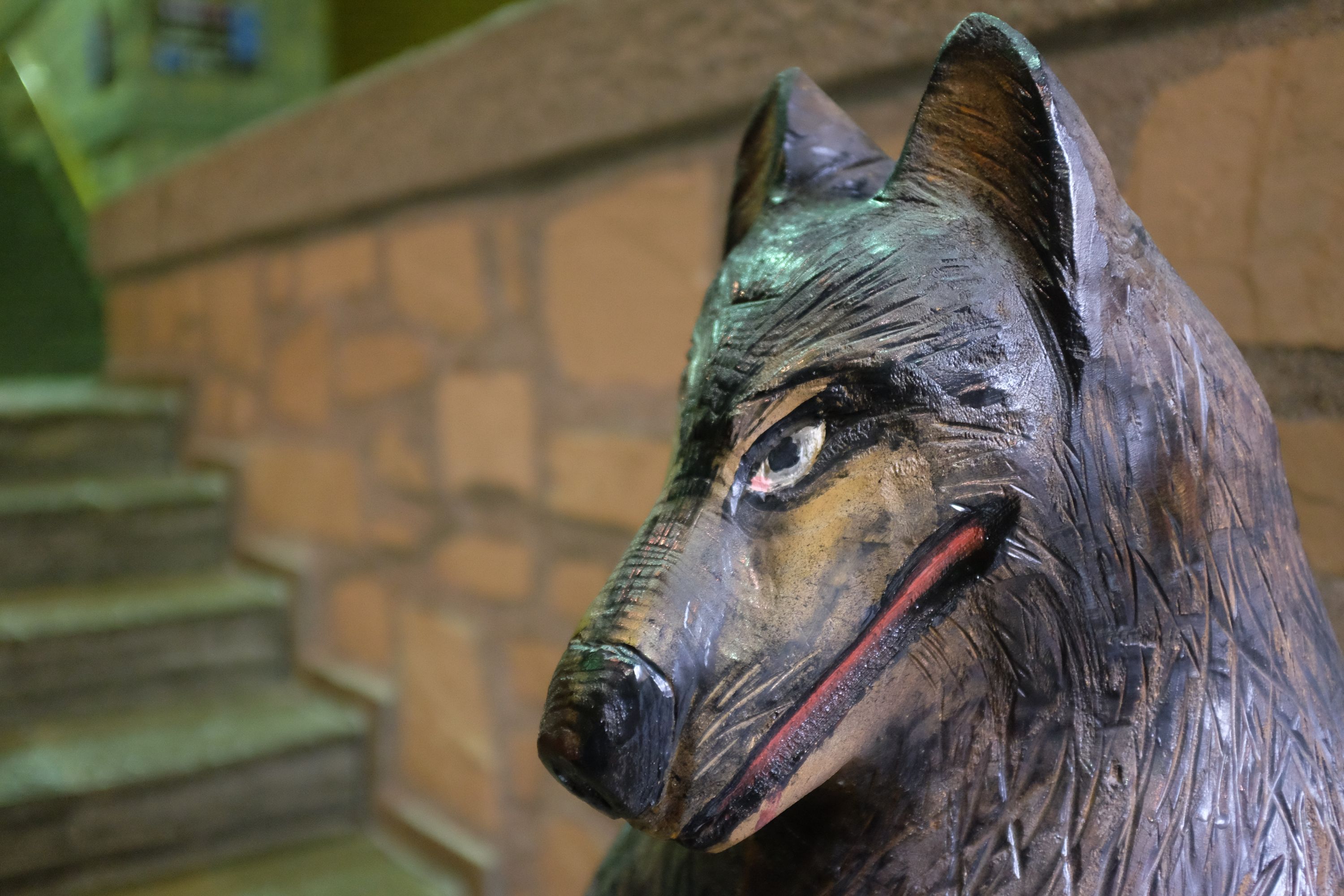 Close-up of a carved wooden statue of a wolf.