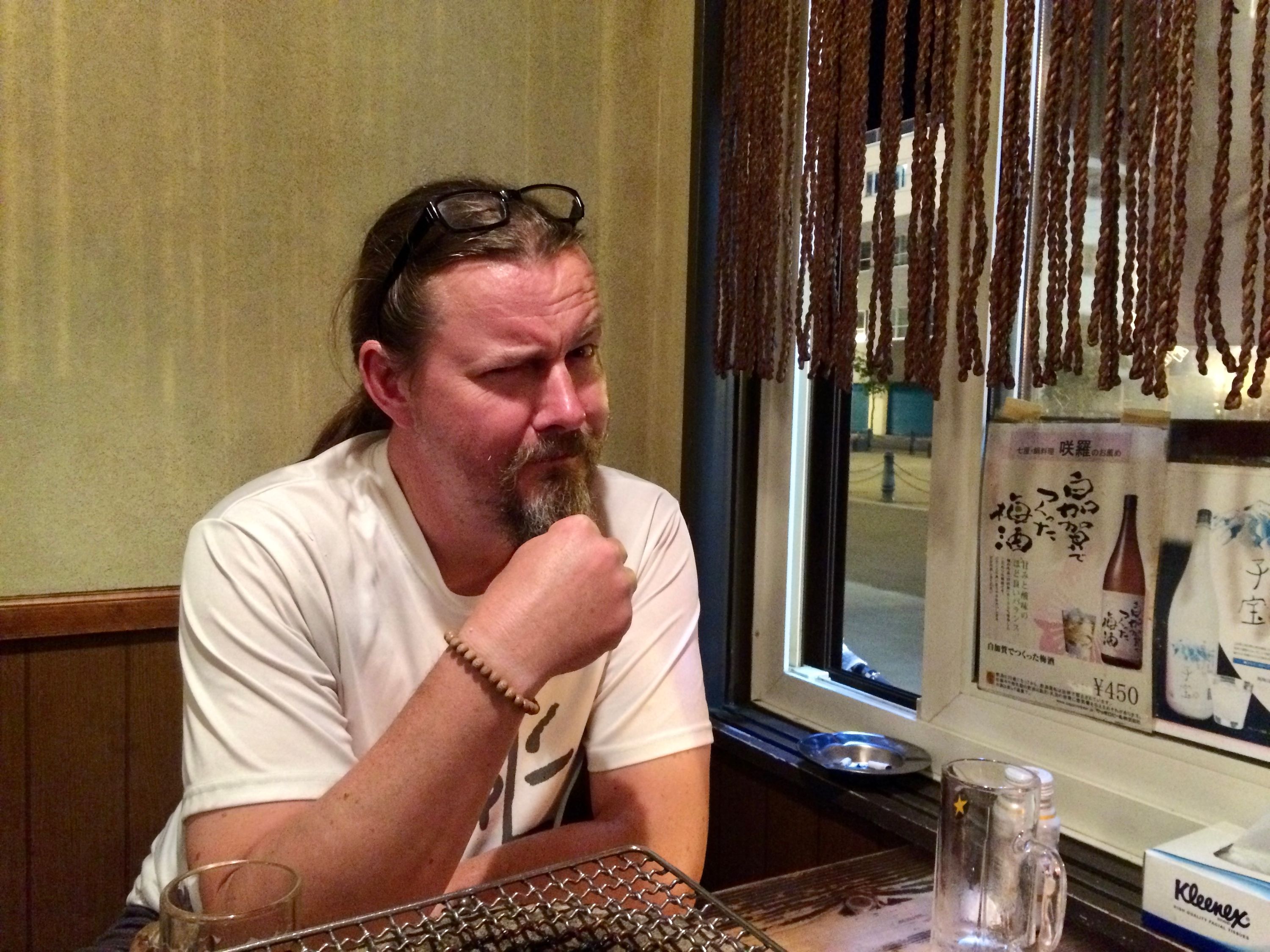 Another European-looking man, the American traveler John Ebert, sits at a table in a bar.