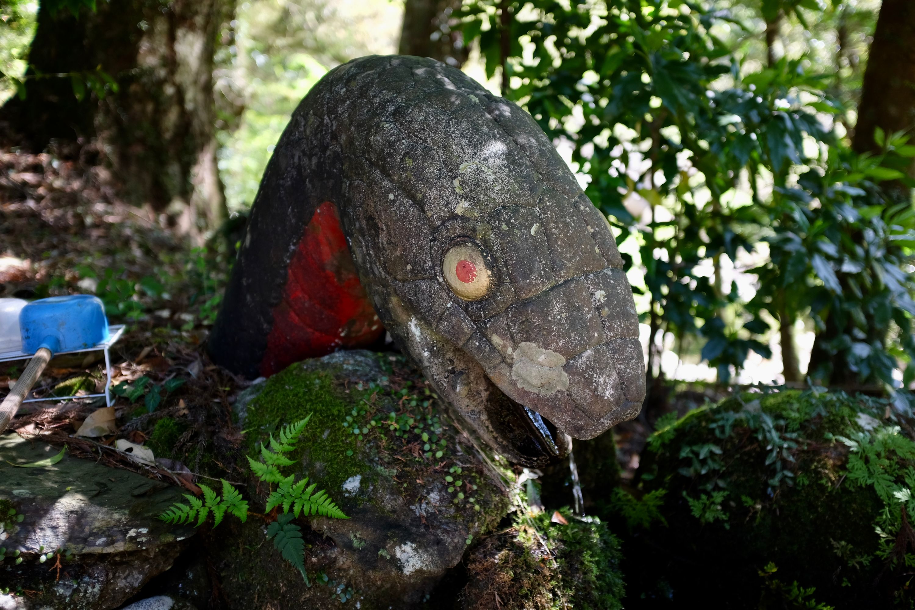 The fountain at the shrine is the head of a large snake, with water pouring from its mouth.