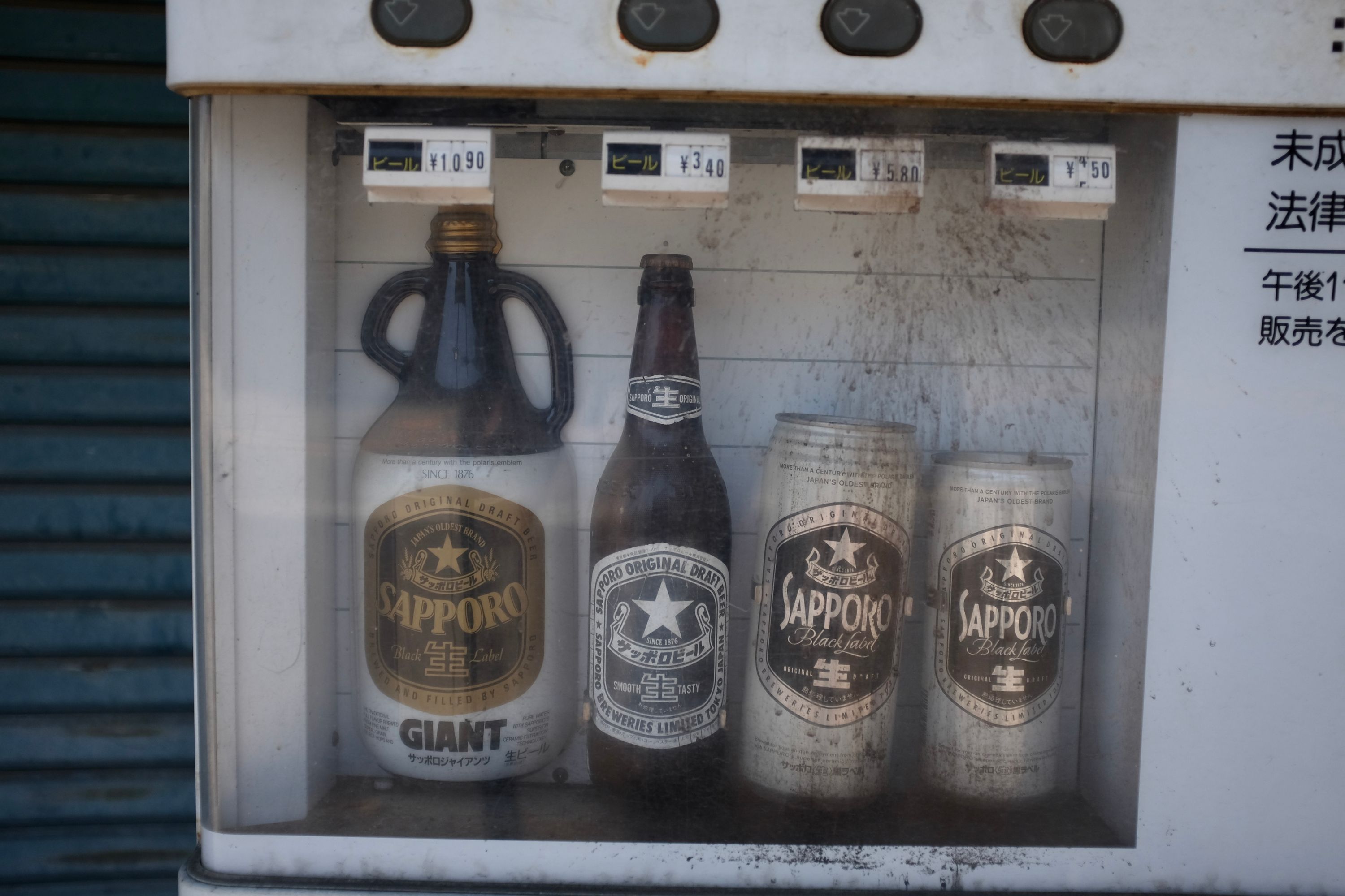 Bottles and cans of Sapporo beer in a vending machine.