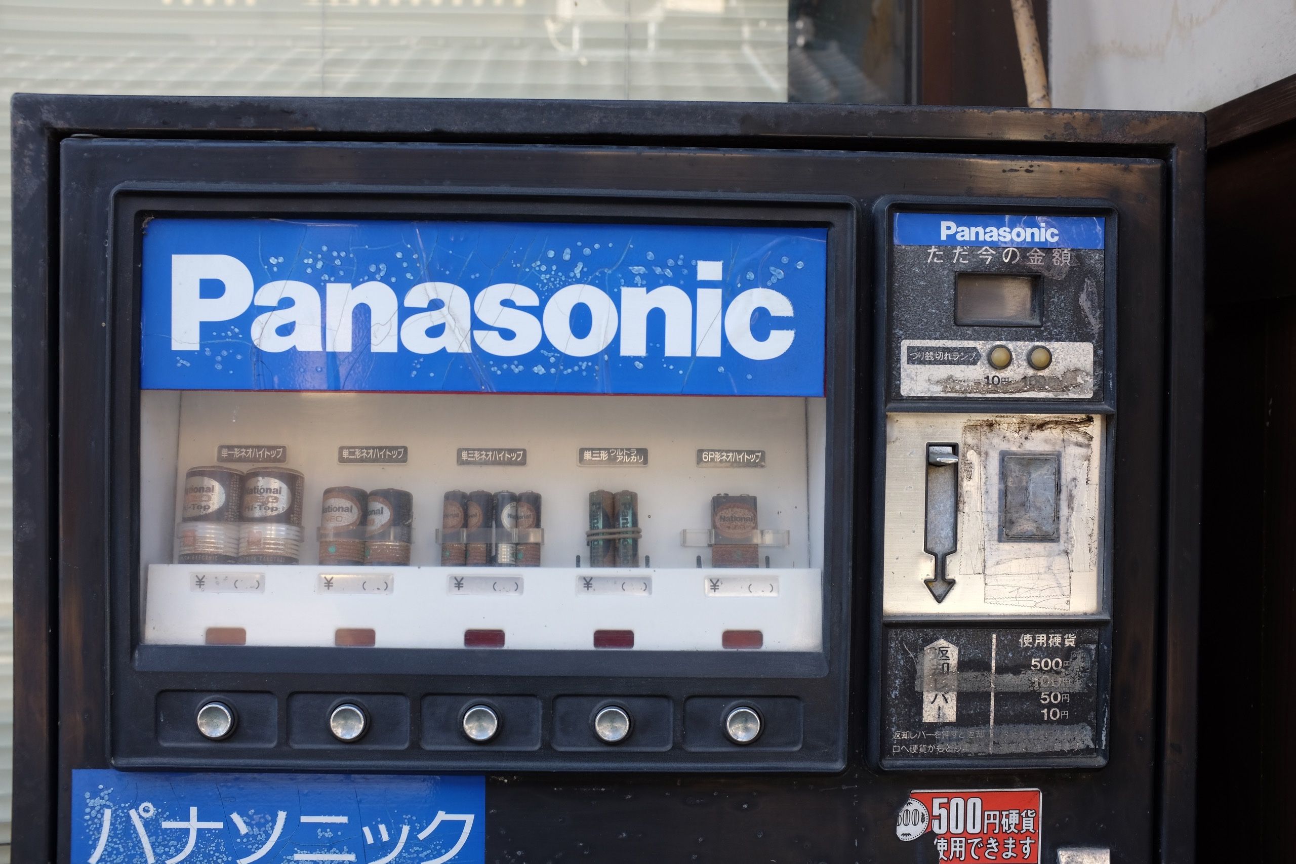 A Panasonic vending machine that sells batteries, now rusty and most likely not working.