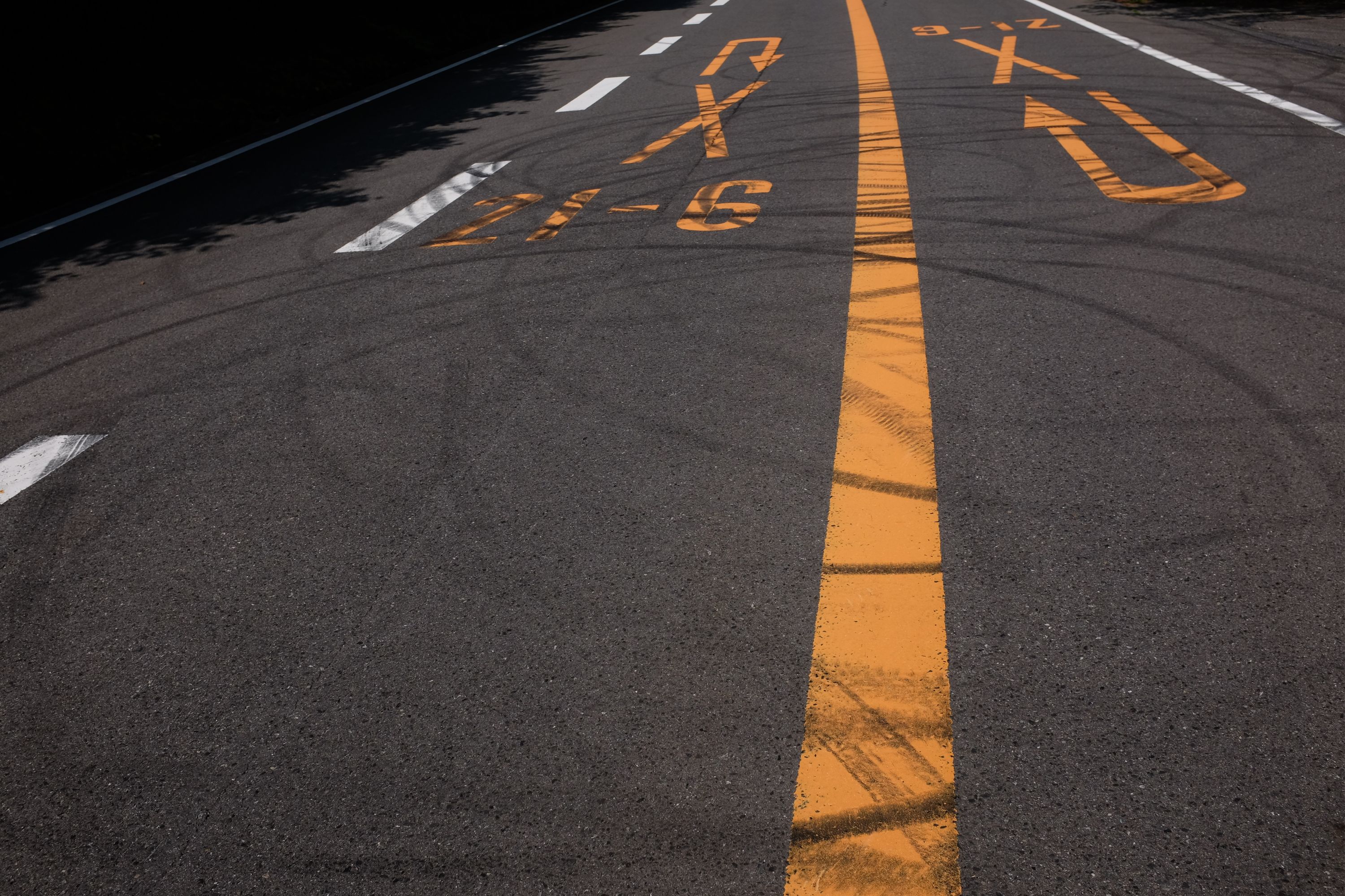 The surface of a mountain road streaked with rubber from road racing.