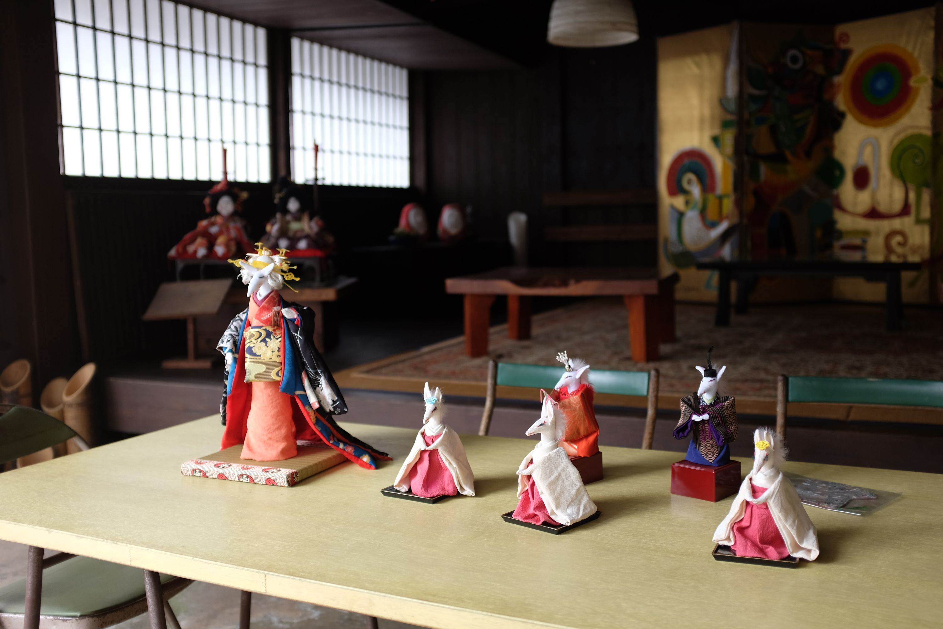 Fox dolls dressed in ceremonial silk gowns in a shop.