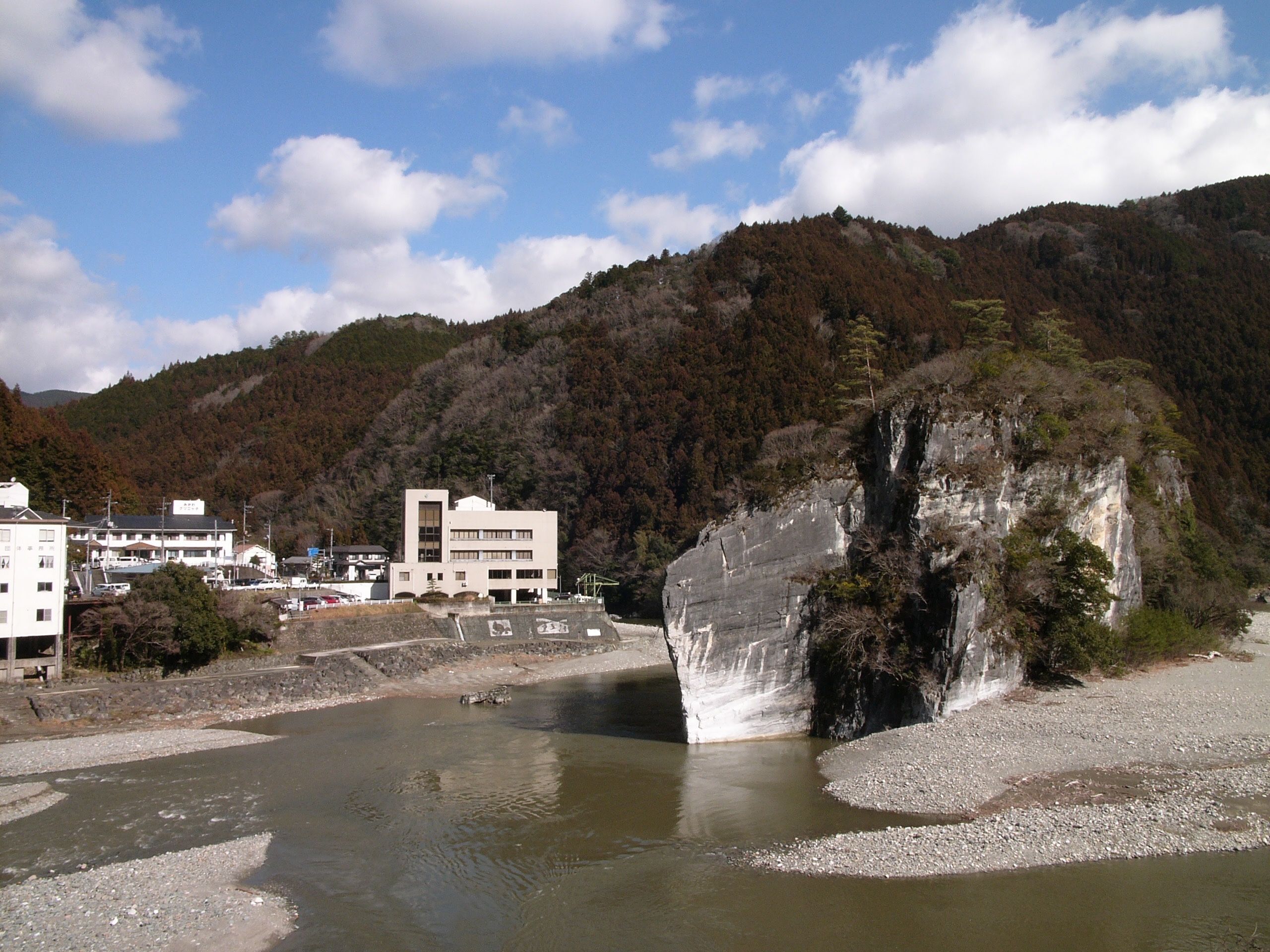 A large grey rock at the confluence of two mountain rivers.