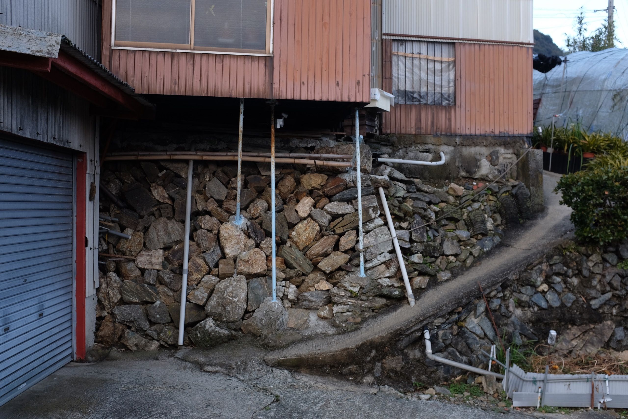 A stone wall underneath a village house, similar to but less elaborate than that of the Garyū Mountain Villa above.
